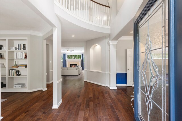 51 N Frosted Pond Dr, The Woodlands, TX 77381 - entrance foyer featuring dark wood-style floors, baseboards, a fireplace, and ornamental molding