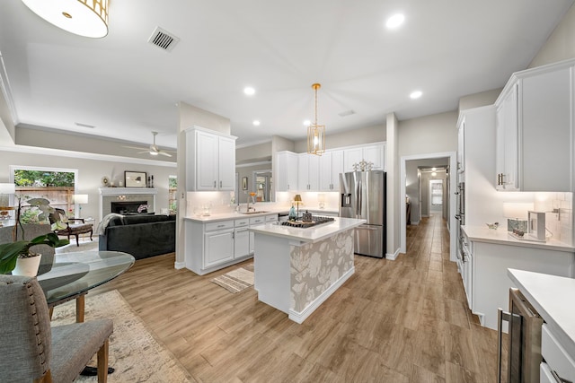 14211 Manderly Dr, Houston, TX 77077 - kitchen with appliances with stainless steel finishes, a sink, ceiling fan, light countertops, and a center island