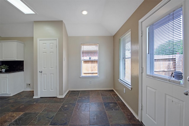 16315 Redbud Berry Ln, Cypress, TX 77433 - unfurnished dining area featuring baseboards, stone tile floors, and vaulted ceiling