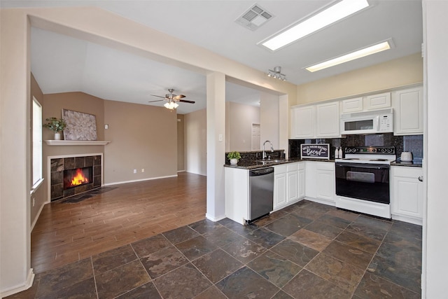 16315 Redbud Berry Ln, Cypress, TX 77433 - kitchen with electric range oven, stainless steel dishwasher, white microwave, dark countertops, and tasteful backsplash