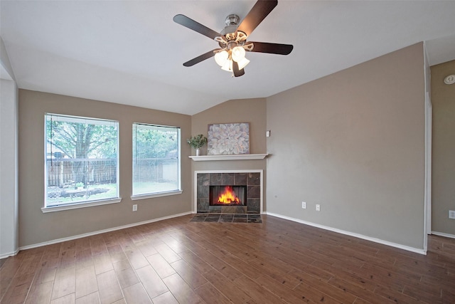 16315 Redbud Berry Ln, Cypress, TX 77433 - unfurnished living room featuring a ceiling fan, wood finished floors, a tiled fireplace, lofted ceiling, and baseboards