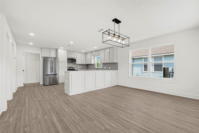 3910 Cetti St, Houston, TX 77009 - kitchen featuring appliances with stainless steel finishes, light wood-style flooring, baseboards, decorative backsplash, and recessed lighting