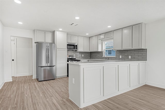 3910 Cetti St, Houston, TX 77009 - kitchen featuring appliances with stainless steel finishes, baseboards, tasteful backsplash, a peninsula, and recessed lighting