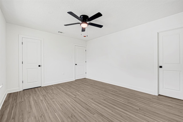 3910 Cetti St, Houston, TX 77009 - unfurnished bedroom featuring light wood-style floors, baseboards, a textured ceiling, and a ceiling fan