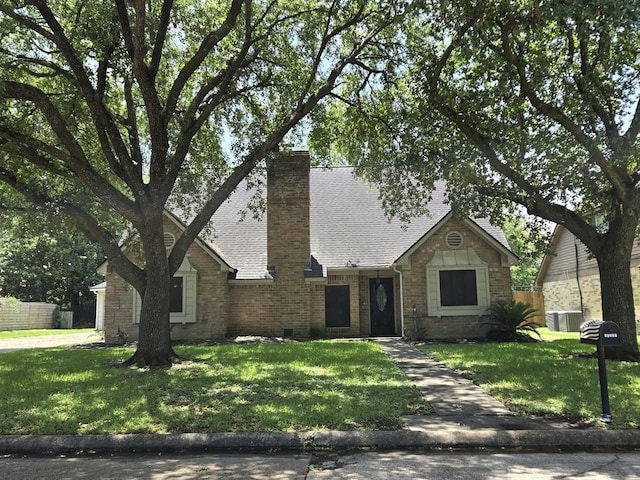 20339 Acapulco Cove Dr, Humble, TX 77346 - view of front of home with a chimney, brick siding, a shingled roof, and central AC unit