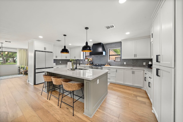 1902 Knoboak Cir, Houston, TX 77080 - kitchen featuring freestanding refrigerator, wall chimney exhaust hood, a sink, light countertops, and decorative backsplash