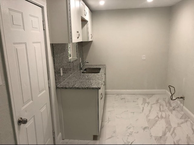 5223 Windemere St, Houston, TX 77033 - kitchen with a sink, baseboards, light marble finish floors, recessed lighting, and dark stone counters