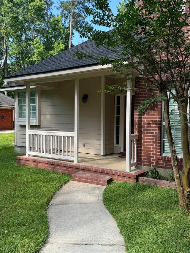2232 Stableridge Dr, Conroe, TX 77384 - entrance to property featuring covered porch, a shingled roof, and a lawn