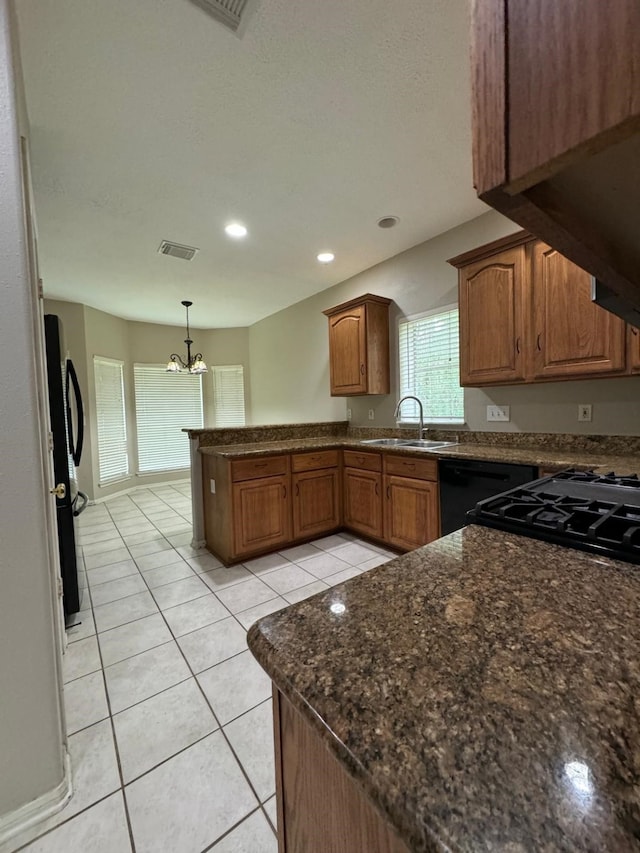 2232 Stableridge Dr, Conroe, TX 77384 - kitchen featuring a sink, a peninsula, a chandelier, light tile patterned floors, and hanging light fixtures