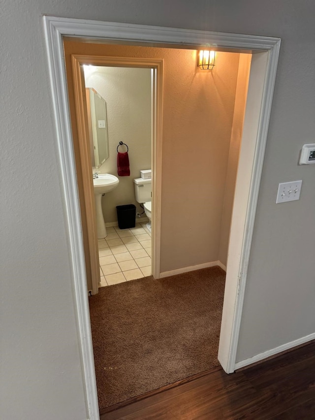2232 Stableridge Dr, Conroe, TX 77384 - hallway featuring baseboards, tile patterned floors, and carpet flooring