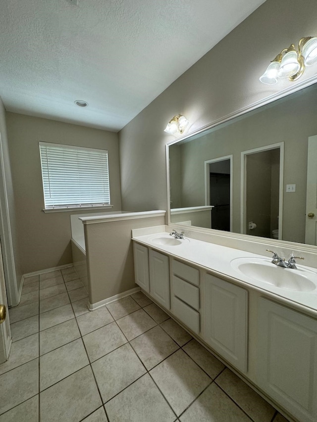 2232 Stableridge Dr, Conroe, TX 77384 - bathroom with double vanity, tile patterned flooring, toilet, and a textured ceiling