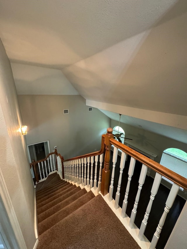 2232 Stableridge Dr, Conroe, TX 77384 - stairs featuring lofted ceiling, carpet flooring, and ceiling fan