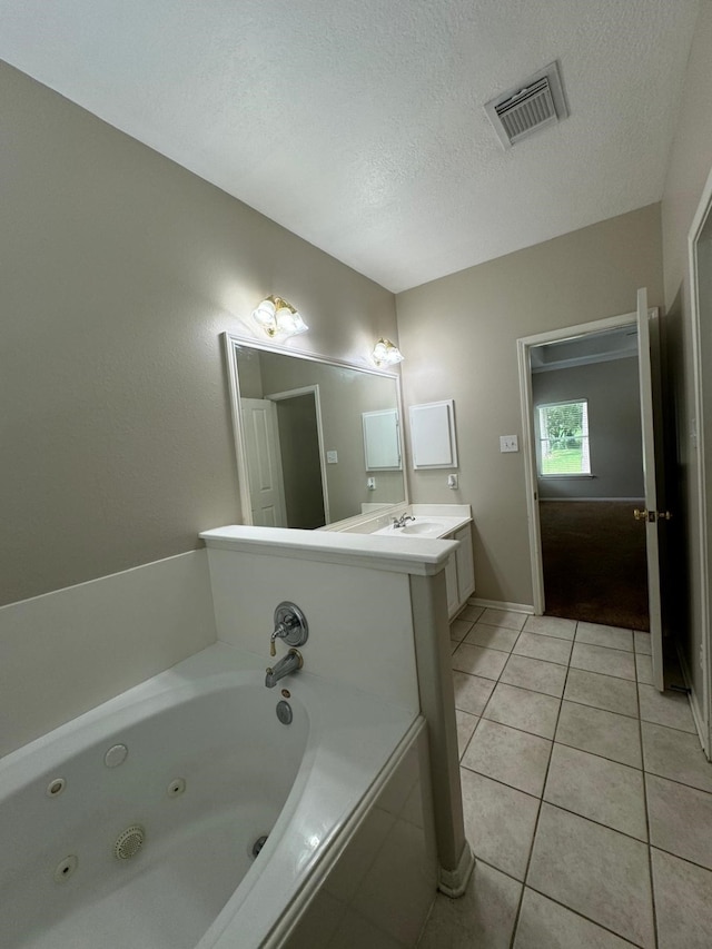 2232 Stableridge Dr, Conroe, TX 77384 - full bath featuring tile patterned floors, a textured ceiling, a jetted tub, vanity, and baseboards