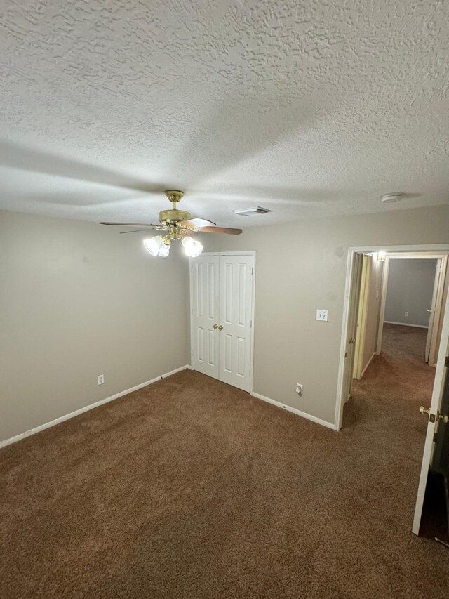 2232 Stableridge Dr, Conroe, TX 77384 - unfurnished bedroom with dark colored carpet, baseboards, ceiling fan, a textured ceiling, and a closet