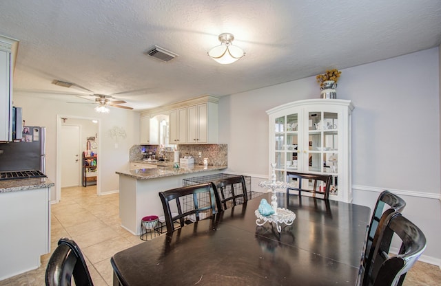 3305 Park Shadow Ln, Deer Park, TX 77536 - dining area featuring ceiling fan, a textured ceiling, light tile patterned flooring, and baseboards