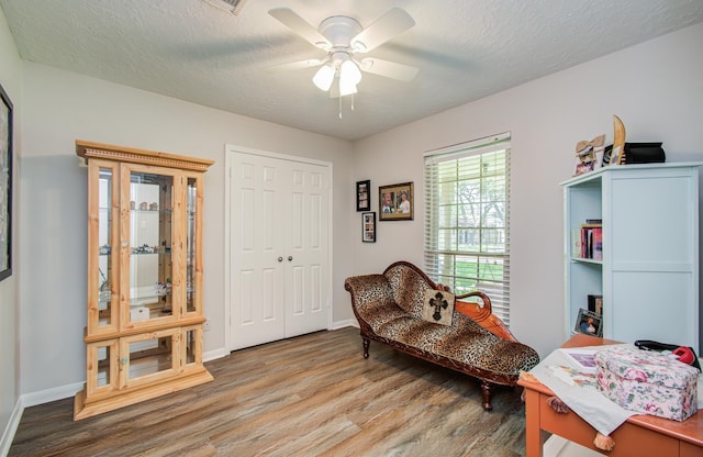 3305 Park Shadow Ln, Deer Park, TX 77536 - sitting room with wood finished floors, ceiling fan, baseboards, and a textured ceiling
