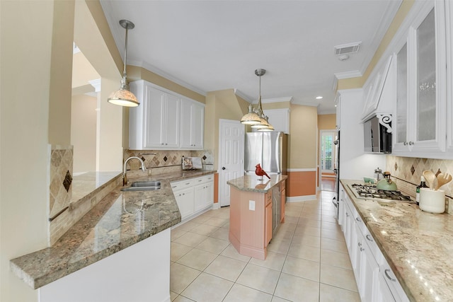 14806 Cantwell Bnd, Cypress, TX 77429 - kitchen featuring decorative backsplash, light stone counters, white cabinets, light tile patterned flooring, and crown molding