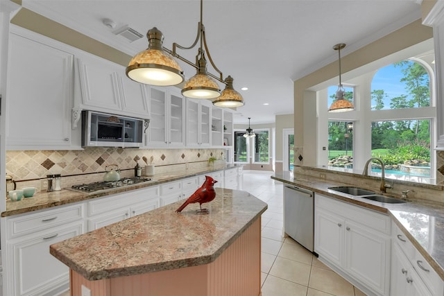 14806 Cantwell Bnd, Cypress, TX 77429 - kitchen featuring stainless steel appliances, decorative backsplash, light tile patterned floors, light stone counters, and crown molding