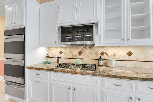 14806 Cantwell Bnd, Cypress, TX 77429 - kitchen featuring stainless steel appliances, a warming drawer, white cabinetry, and light stone countertops