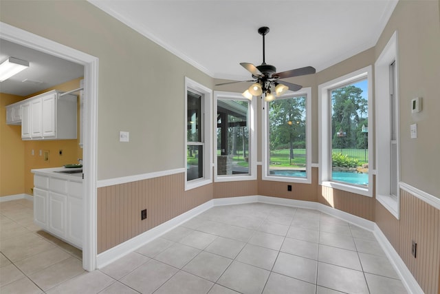 14806 Cantwell Bnd, Cypress, TX 77429 - unfurnished dining area featuring wainscoting, light tile patterned floors, ceiling fan, ornamental molding, and wood walls
