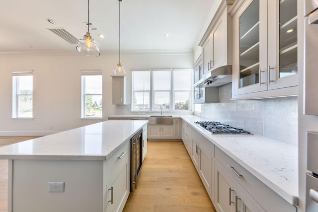 3311 Green Lilly Ln, Houston, TX 77008 - kitchen with a sink, stainless steel gas stovetop, crown molding, decorative backsplash, and a center island