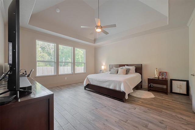 13707 Rivendell Crest Ln, Cypress, TX 77429 - bedroom with a tray ceiling, light wood-style flooring, a ceiling fan, and crown molding
