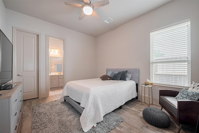 13707 Rivendell Crest Ln, Cypress, TX 77429 - bedroom with light wood-type flooring, connected bathroom, and a ceiling fan