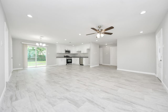 5911 Southurst St, Houston, TX 77033 - unfurnished living room with recessed lighting, ceiling fan, baseboards, and a chandelier