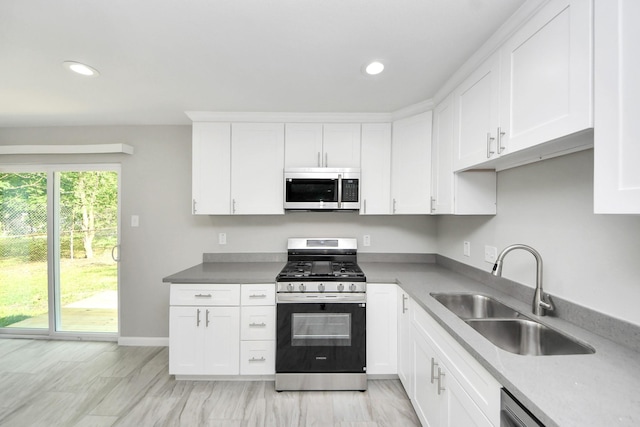 5911 Southurst St, Houston, TX 77033 - kitchen with stainless steel appliances, a sink, white cabinetry, recessed lighting, and baseboards