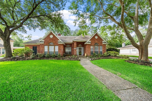 1523 Lofty Maple Trl, Kingwood, TX 77345 - view of front facade featuring brick siding, a front lawn, a chimney, and a shingled roof