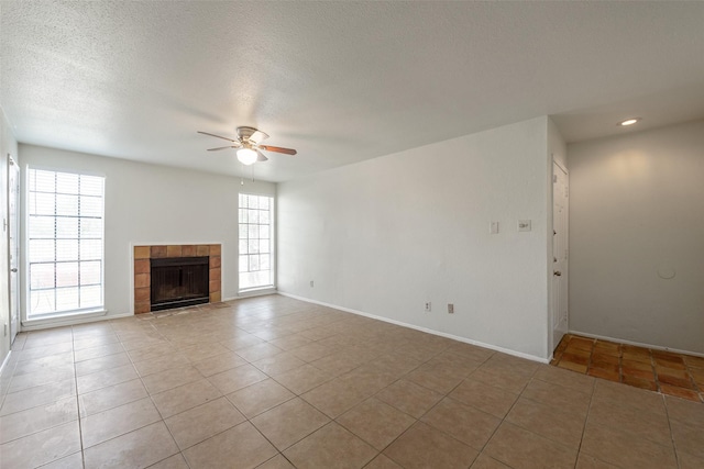12500 Sandpiper Dr Unit 5, Houston, TX 77035 - unfurnished living room with ceiling fan, light tile patterned floors, a tile fireplace, baseboards, and a textured ceiling