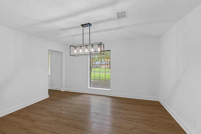 16218 Coral Bay St, Crosby, TX 77532 - unfurnished dining area with dark wood-style flooring, a chandelier, baseboards, and a textured ceiling