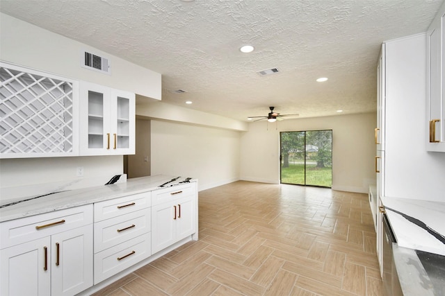 1003 Crescent Blvd, Cleveland, TX 77327 - kitchen featuring ceiling fan, baseboards, a textured ceiling, white cabinetry, and open floor plan