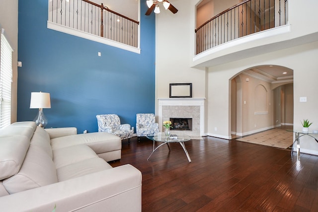 26706 Grey Swan Dr, Katy, TX 77494 - living room with a high ceiling, a ceiling fan, hardwood / wood-style floors, arched walkways, and baseboards