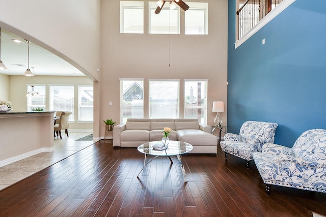 26706 Grey Swan Dr, Katy, TX 77494 - living room featuring a ceiling fan, a towering ceiling, arched walkways, hardwood / wood-style flooring, and baseboards