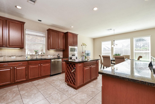 26706 Grey Swan Dr, Katy, TX 77494 - kitchen featuring appliances with stainless steel finishes, a sink, a kitchen island, decorative backsplash, and recessed lighting