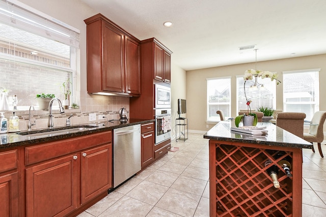 26706 Grey Swan Dr, Katy, TX 77494 - kitchen with stainless steel appliances, a sink, backsplash, a chandelier, and light tile patterned floors
