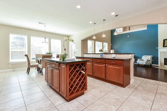 26706 Grey Swan Dr, Katy, TX 77494 - kitchen with a kitchen island, light tile patterned floors, recessed lighting, pendant lighting, and a tile fireplace
