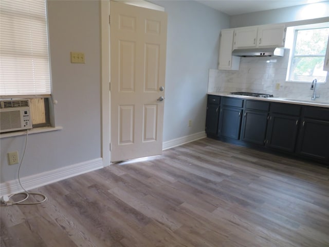 1103 Jocelyn St, Houston, TX 77023 - kitchen with gas cooktop, tasteful backsplash, a sink, light wood-style floors, and baseboards