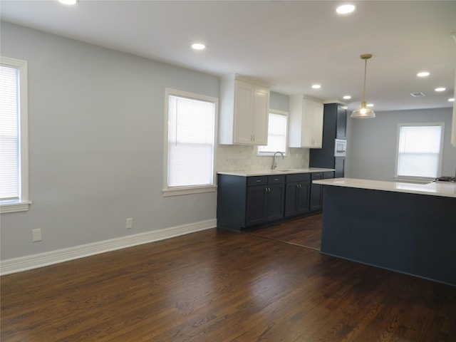 1103 Jocelyn St, Houston, TX 77023 - kitchen featuring dark wood-style floors, light countertops, a sink, recessed lighting, and baseboards