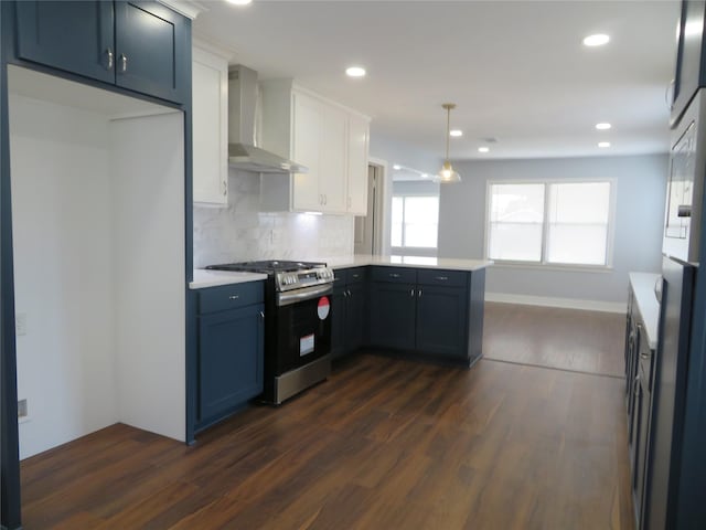 1103 Jocelyn St, Houston, TX 77023 - kitchen featuring wall chimney exhaust hood, stainless steel gas stove, a peninsula, dark wood-style flooring, and recessed lighting