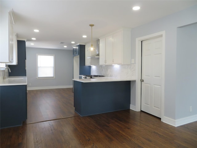 1103 Jocelyn St, Houston, TX 77023 - kitchen with a peninsula, light countertops, tasteful backsplash, dark wood finished floors, and baseboards