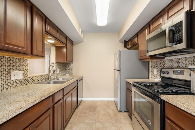 16111 Aspenglenn Dr Unit 803, Houston, TX 77084 - kitchen with stainless steel appliances, a sink, baseboards, backsplash, and light stone counters