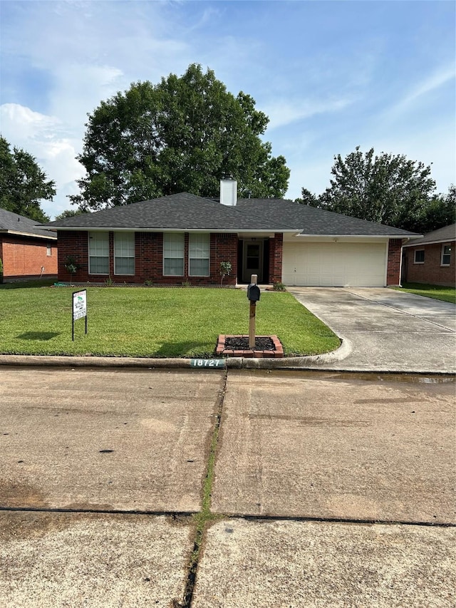 18727 Parfield Ln, Houston, TX 77084 - ranch-style home with concrete driveway, brick siding, an attached garage, a front yard, and a chimney
