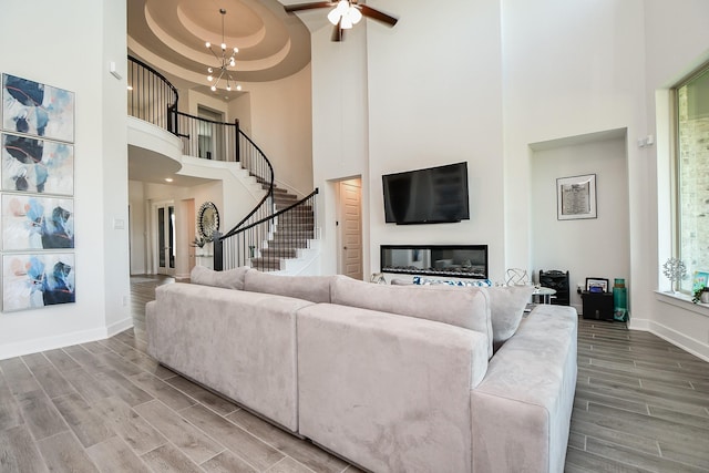 31142 Crescent Hill Dr, Fulshear, TX 77441 - living room featuring a high ceiling, stairs, baseboards, wood tiled floors, and ceiling fan