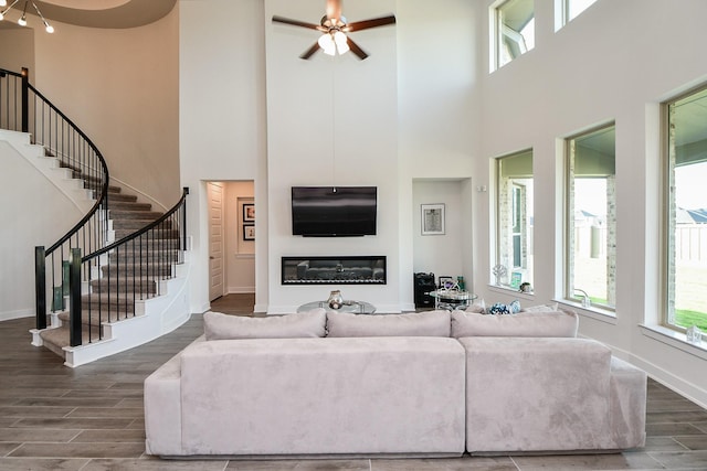31142 Crescent Hill Dr, Fulshear, TX 77441 - living area with a towering ceiling, wood finished floors, stairway, baseboards, and a ceiling fan