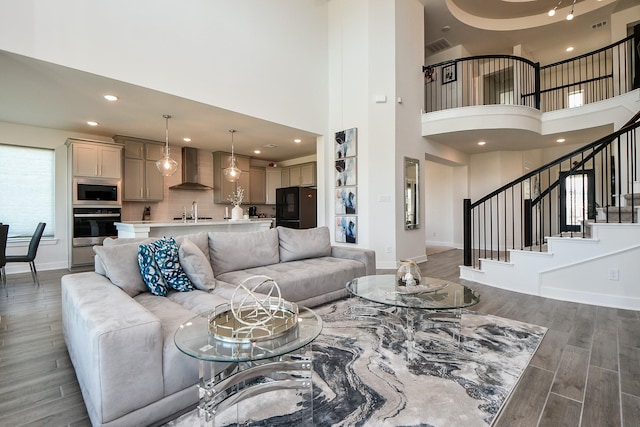 31142 Crescent Hill Dr, Fulshear, TX 77441 - living room with a high ceiling, light wood-style flooring, baseboards, stairway, and recessed lighting