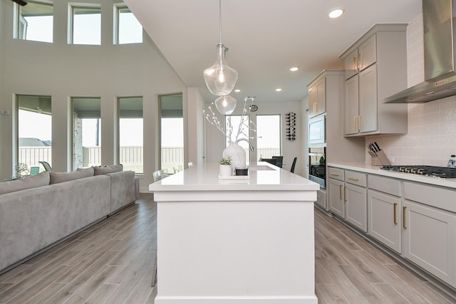 31142 Crescent Hill Dr, Fulshear, TX 77441 - kitchen featuring wall chimney exhaust hood, stainless steel gas stovetop, wall oven, gray cabinetry, and recessed lighting