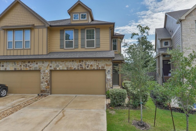 162 Cheswood Forest Pl, Montgomery, TX 77316 - view of front of home featuring board and batten siding, stone siding, driveway, an attached garage, and a front lawn