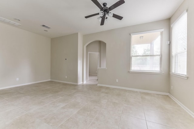 162 Cheswood Forest Pl, Montgomery, TX 77316 - unfurnished room with light tile patterned floors, a ceiling fan, arched walkways, and healthy amount of natural light